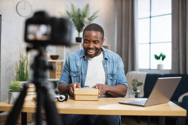 istock Man filming on camera unpacking process of paper box 1363833196