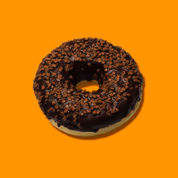 istock delicious donuts with dark chocolate isolated on orange background 2 1363833295