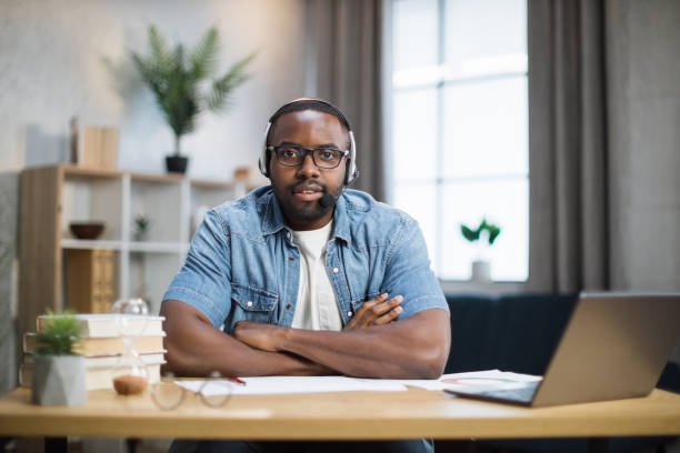 istock African man in headset and eyeglasses sitting at desk 1363833413