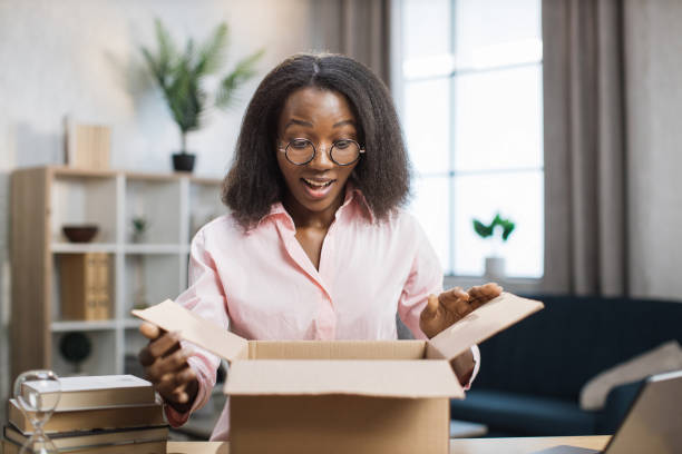istock Surprised african woman unpacking parcel box 1363833627