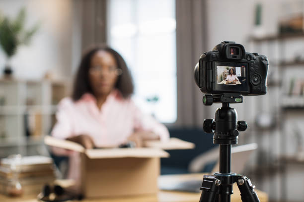 istock African woman unboxing parcel and recording video 1363833697
