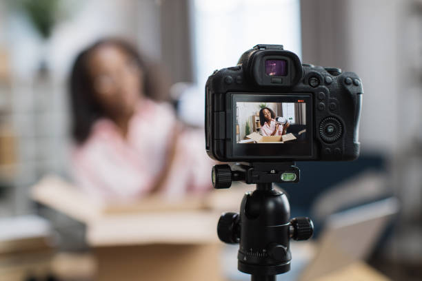 African woman filming video while unpacking VR goggles