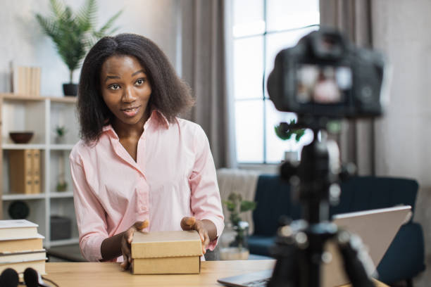 istock African woman recording video blog while opening parcel box 1363833861