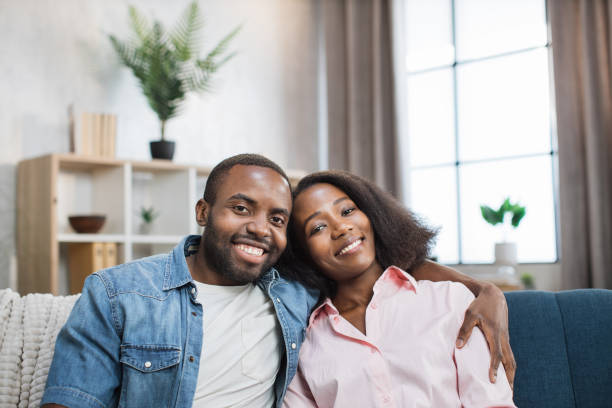 istock African couple hugging while resting together on couch 1363834394
