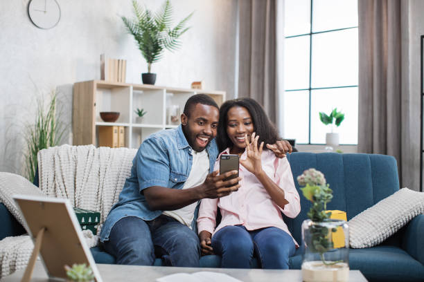 istock Cheerful couple taking selfie on smartphone at home 1363834415