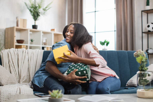 istock Happy couple embracing while sharing with presents at home 1363834496