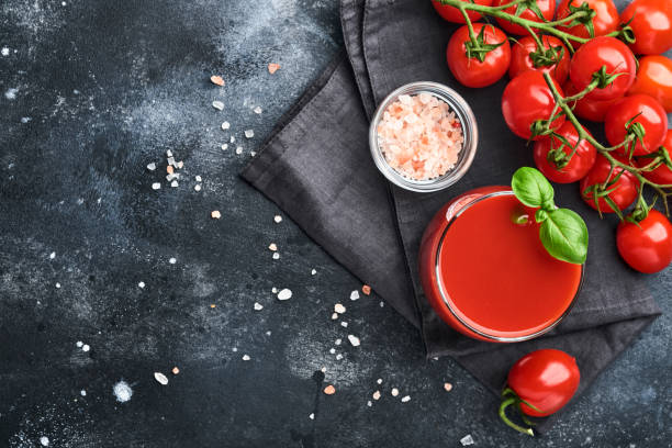 glass of fresh tomato juice, salt, basil and tomatoes on black plate on old black background. top view with copy space. - healthy eating food and drink nutrition label food imagens e fotografias de stock