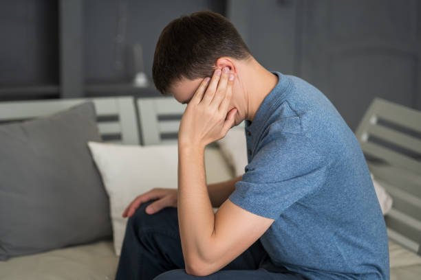 man with earache, ear pain at home - tinitus imagens e fotografias de stock