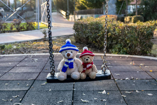 istock Two teddy bears sitting on the swing 1363839932
