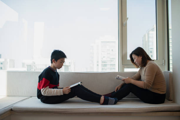 istock A mother and her son sat on the windowsill reading 1363840769