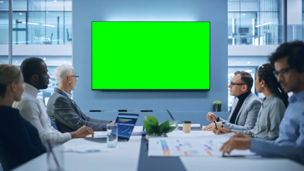 istock Multi-Ethnic Office Conference Room Meeting: Diverse Team of Successful Managers, Executives Talk, Use Green Screen Chroma Key TV. Group of Businesspeople Work on Strategy for an e-Commerce Startup 1363840921