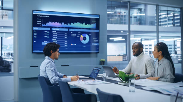 istock Multi-Ethnic Office Conference Room Meeting: Team of Three Creative Entrepreneurs Talk, Discuss Growth Strategy. Stylish Young Businesspeople work on Digital e-Commerce Startup, Uses TV Screen. 1363841473