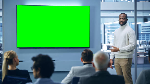 istock Modern Product Presentation Event: Black Businessman Speaks, Explains Concept, Uses Green Chroma Key Screen TV. Press Conference for Group of Diverse Investors, Digital Entrepreneurs, Businesspeople 1363841680