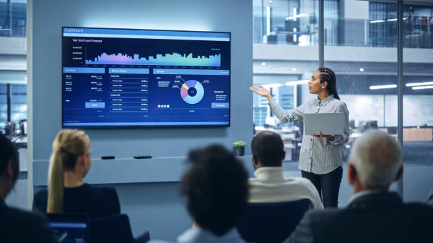 istock Modern Product Presentation Event: Black Businesswoman Talks about e-Commerce Product Big Data Statistics, Charts, Revenue Growth Infographics. Live Press Conference for Digital Businesspeople 1363841727