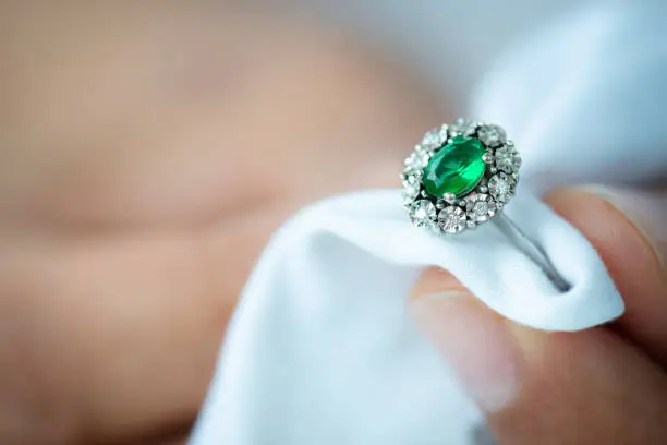 Jeweler is polishing diamond ring.