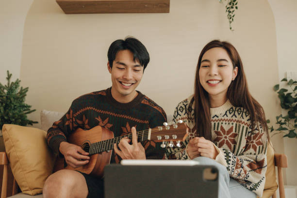 Asian friends playing music together through a video call on the internet. stock photo