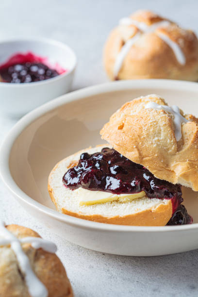istock Traditional Easter cross buns with raisins, butter and jam on gray background. 1363849635