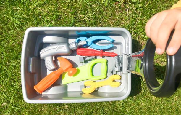 istock Toy wheelbarrow on grass and repair tools. 1363851051