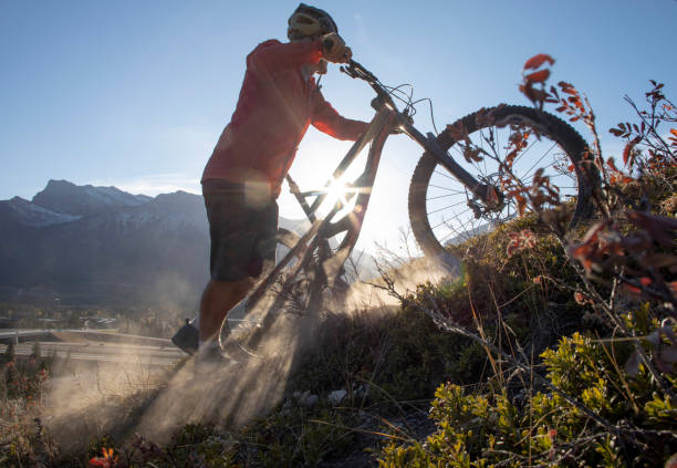 istock Mountain biker pushes bike up dusty slope 1363851143