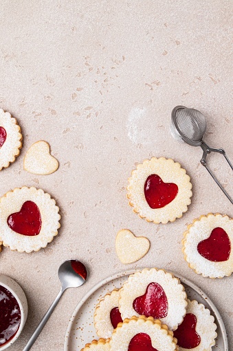 Linzer cookies in shape of heart with jam on light background. Mother's day, Women's day, Valentine's day. Homemade present. Copy space, top view.