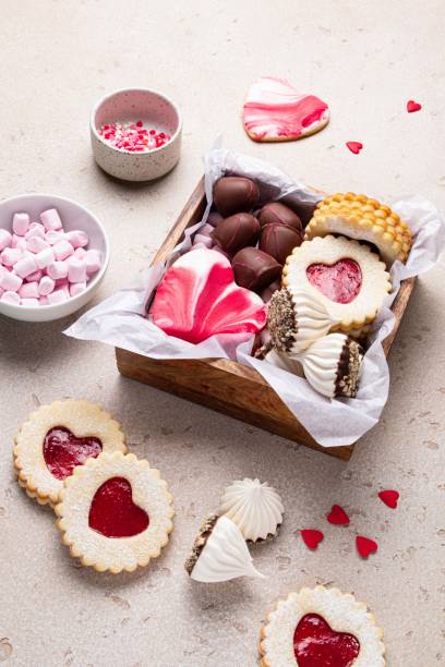 木箱のバレンタインデーのお菓子やクッキー。チョコレート、キャンディー、メレンゲ、マシュマロ、リンツァークッキー、ジンジャーブレッド。母の日、女性の日。自家製プレゼント。選� - chocolate candy gift package chocolate ストックフォトと画像