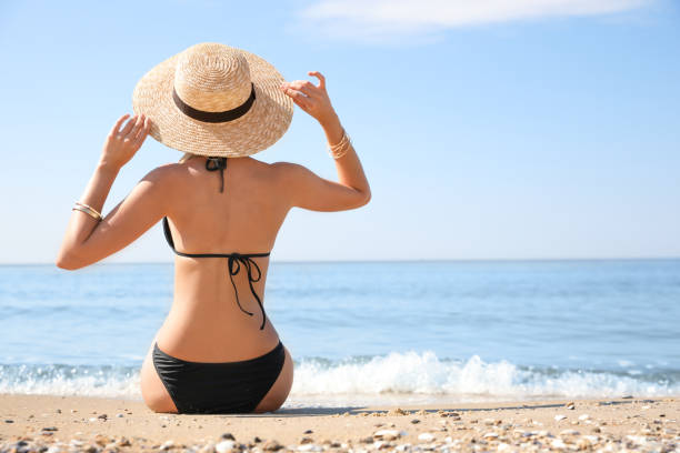 istock Young woman with beautiful body on sandy beach. Space for text 1363854863