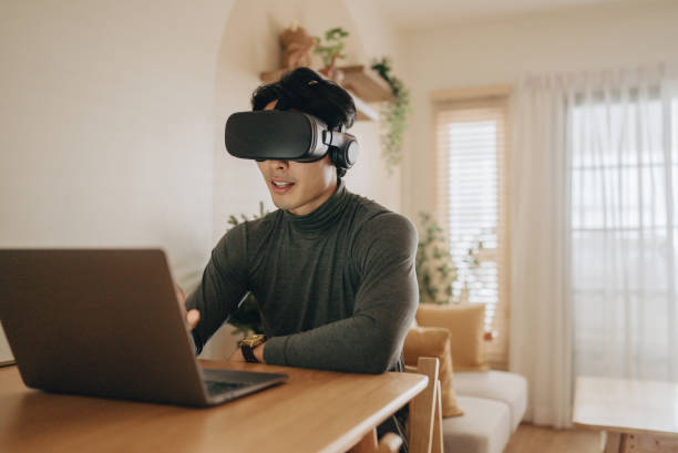 Young man with VR headset exploring virtual reality stock photo