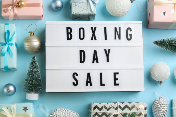 istock Lightbox with phrase BOXING DAY SALE and Christmas decorations on light blue background, flat lay 1363856271