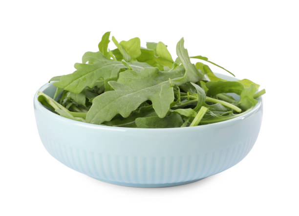 istock Delicious fresh arugula in light blue bowl isolated on white 1363856292
