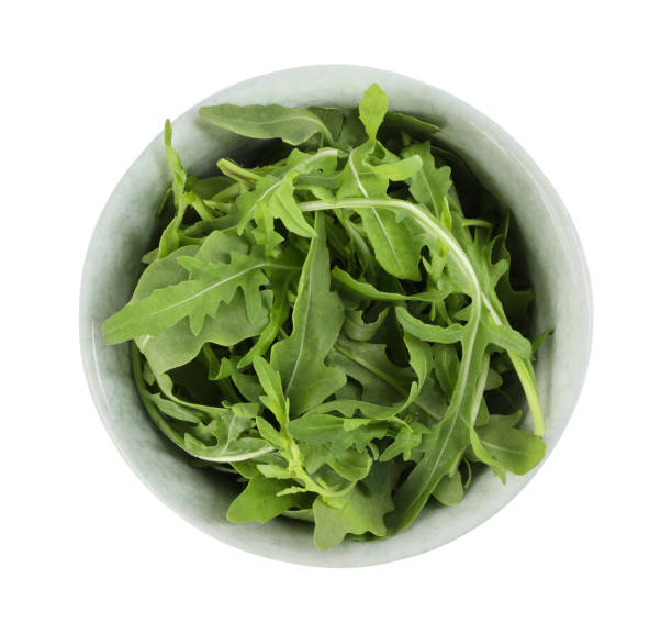 istock Delicious fresh arugula in bowl isolated on white, top view 1363856366