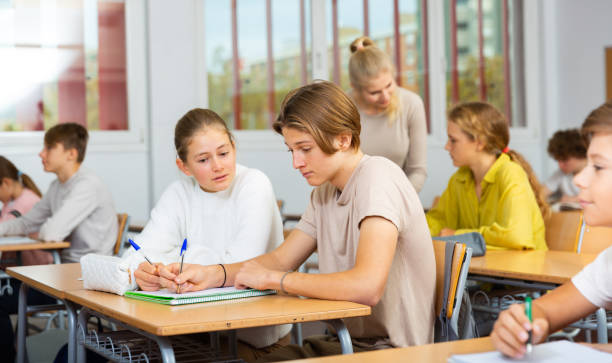 istock Group of school kids and teacher during lesson 1363856515
