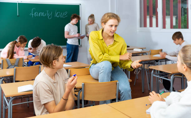 istock Positive students are talking about homework at desk 1363856533