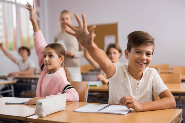 istock School pupils raise their hands up in classroom 1363856591
