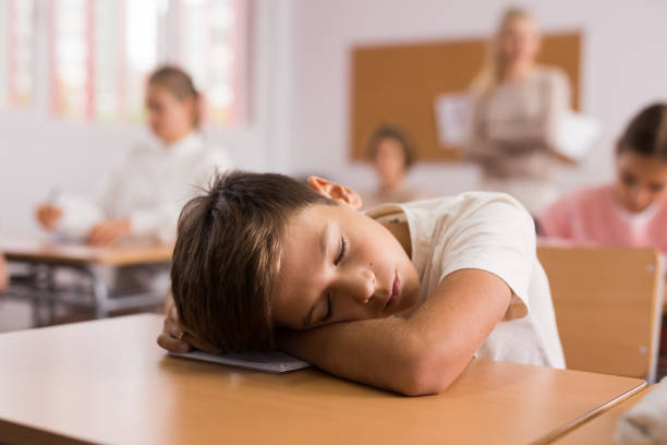 istock Tired bored teenage schoolboy sleeping 1363856599