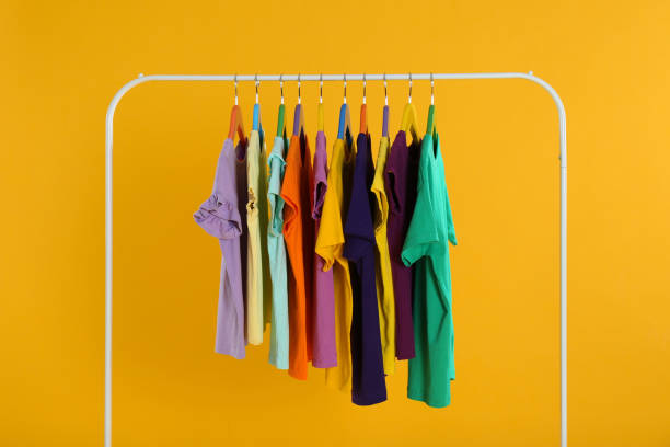 istock Rack with stylish children clothes on yellow background 1363857168