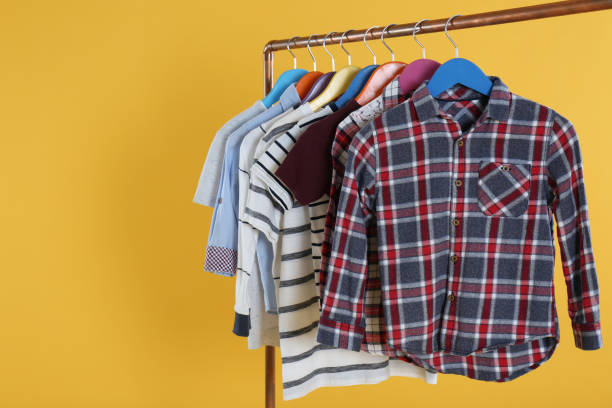 istock Rack with stylish children clothes on yellow background 1363857258