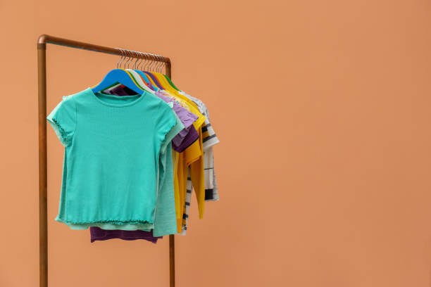 istock Rack with stylish children clothes on beige background. Space for text 1363857259