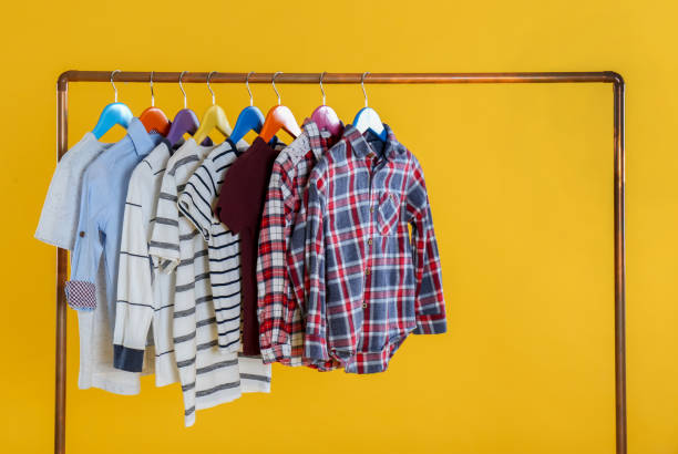 istock Rack with stylish children clothes on yellow background 1363857638