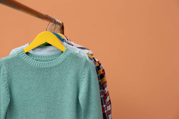 istock Rack with stylish children clothes on beige background, closeup. Space for text 1363857707