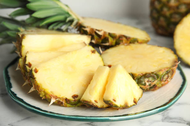 istock Plate with tasty cut pineapple on table, closeup 1363858480