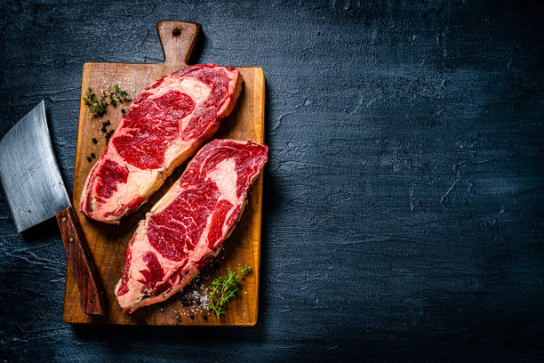 rohe rindersteakfilets auf dunklem tisch. speicherplatz kopieren - meat beef raw freshness stock-fotos und bilder