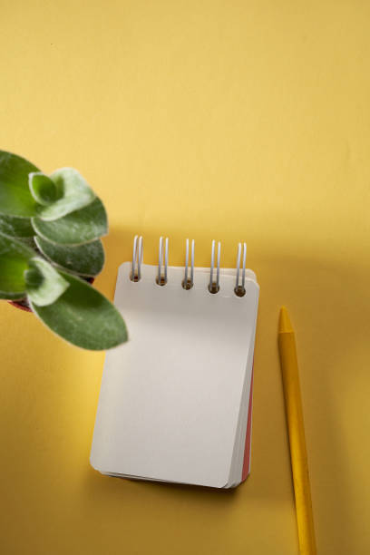 istock blank spiral note pad with yellow color crayon on yellow background 1363860583