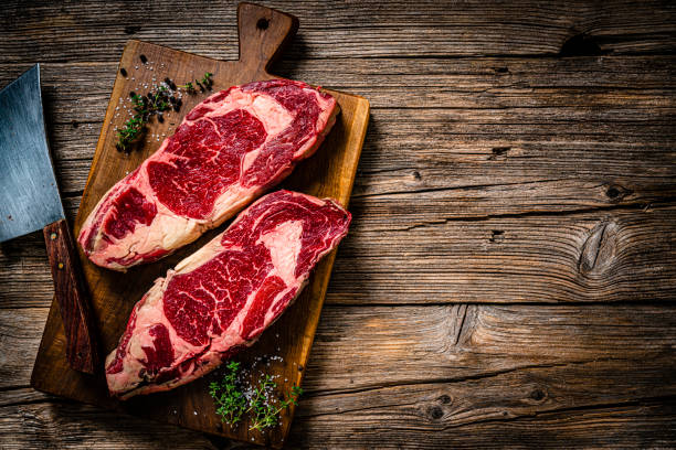 istock Raw beef steak fillets on wooden table. Copy space 1363860589
