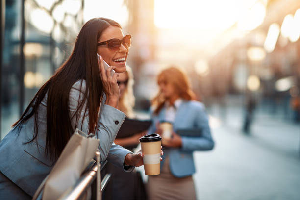 istock Attractive smiling woman using phone in front of her officce 1363861264