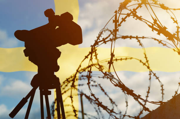istock Double exposure - camera, barbed wire and flag Sweden 1363861350