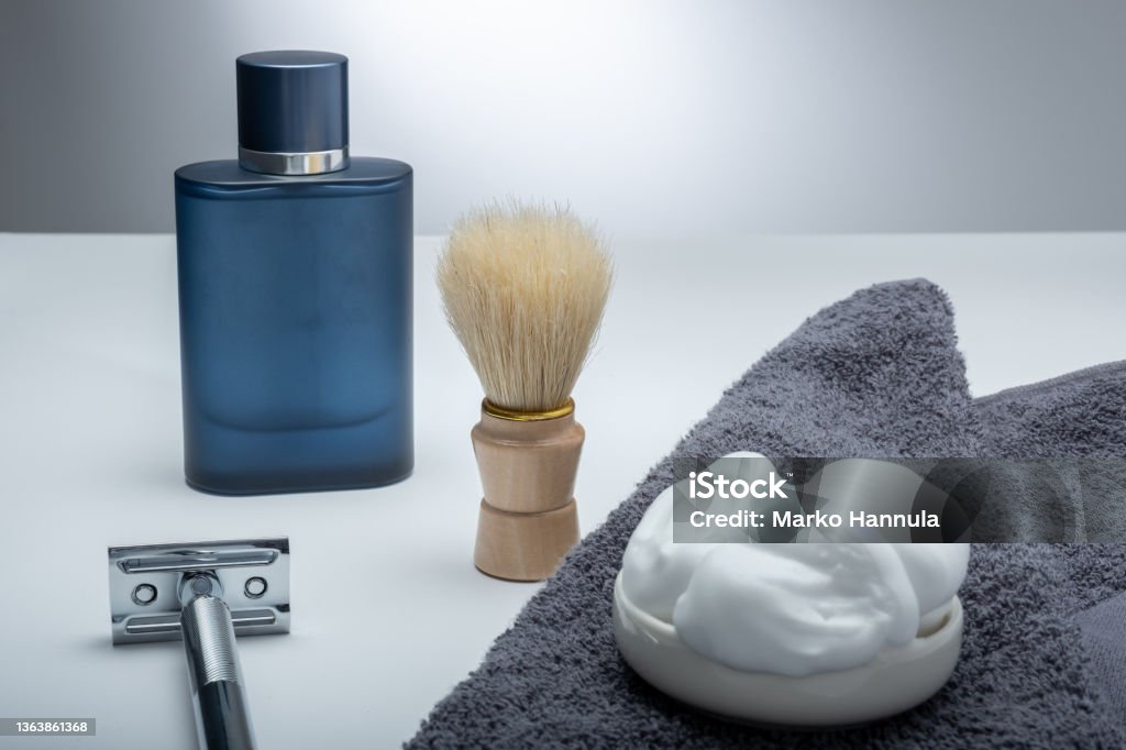 Closeup of men's toilet accessories: a razor, a shaving brush and some shaving foam. Helsinki / Finland - JANUARY 10, 2022: Closeup of men's toilet accessories: a razor, a shaving brush and some shaving foam. Beard Stock Photo