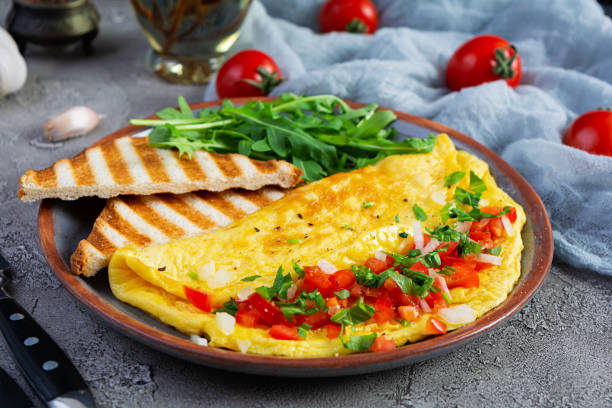 istock Fried omelette with tomatoes, onion and herbs. Delicious breakfast with eggs and toasts 1363864526