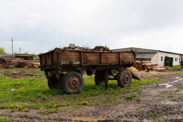 istock Old abandoned rusty tractor trailer. Stands on a green lawn in a muddy puddle. 1363864799