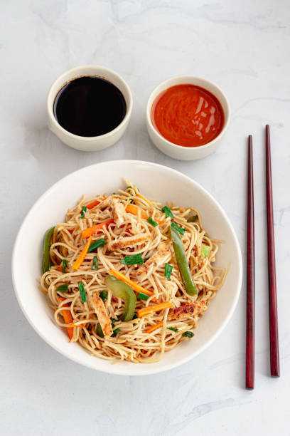 istock Simple Chicken Chow Mein with Chopsticks Top Down Vertical Photo on White Background 1363864805