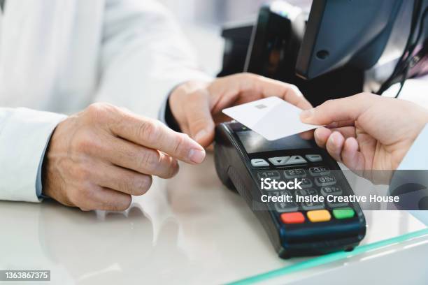 Closeup Cropped Image Of Ecommerce Ebanking Cashless Wireless Payment With Credit Card At Drugstore Pharmacy At Cash Point Desk Buying Medicines Drugs Pills Stock Photo - Download Image Now